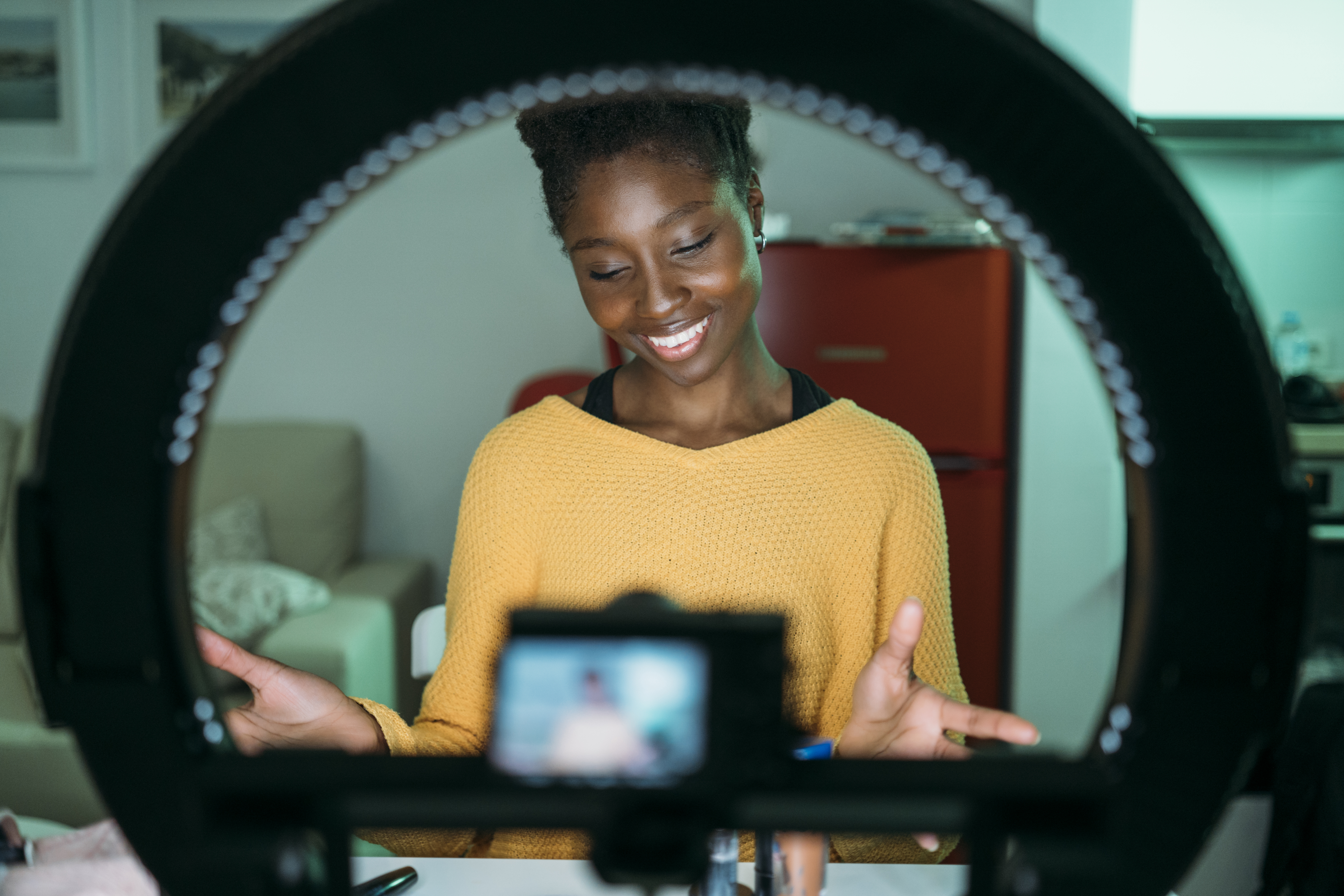 In a trendy indoor setting, a vlogger is utilizing a ring light for creating video content image de V-loggeuse