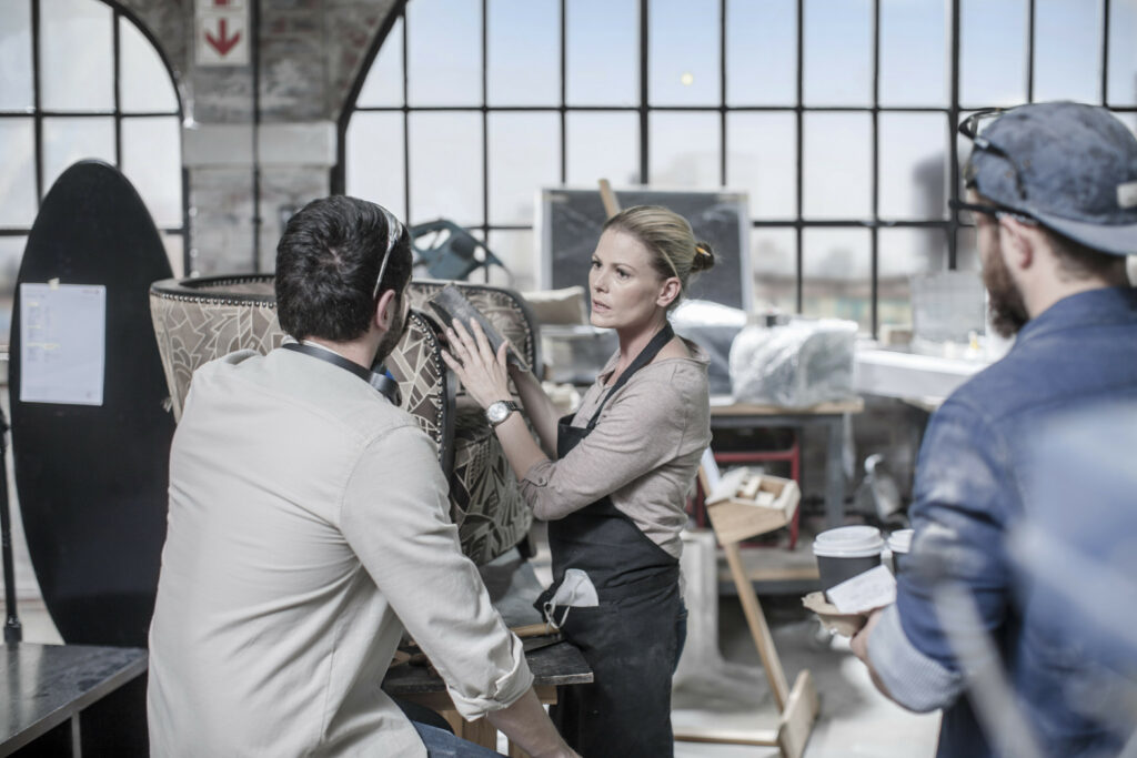 Femme dans un atelier qui explique devant la caméra la confection d'un fauteuil